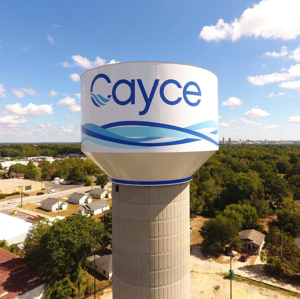 City of Cayce Alex St water tank with blue wave logo, Columbia SC skyline in the background