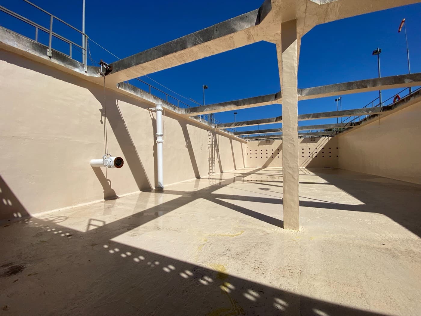 Freshly lined concrete basin at the Monroe water treatment plant under a blue sky