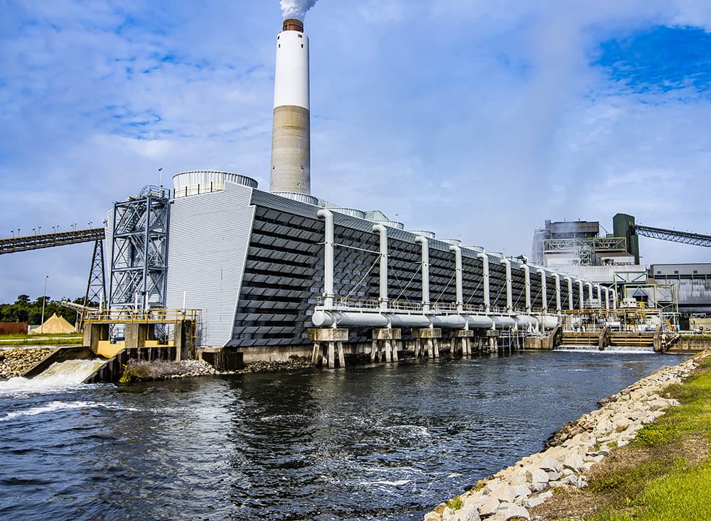 Williams Station cooling tower with white riser piping along the canal and the plant stack behind it, Goose Creek, SC